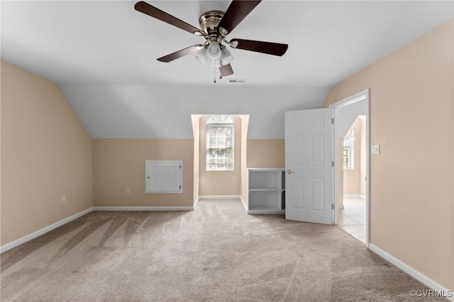 additional living space with light carpet, lofted ceiling, and ceiling fan