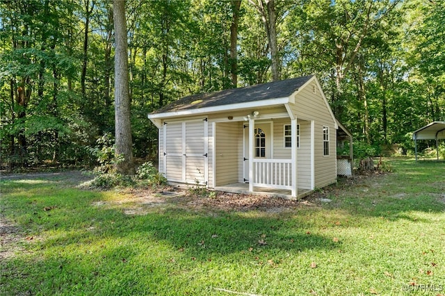 view of outbuilding featuring a lawn and covered porch