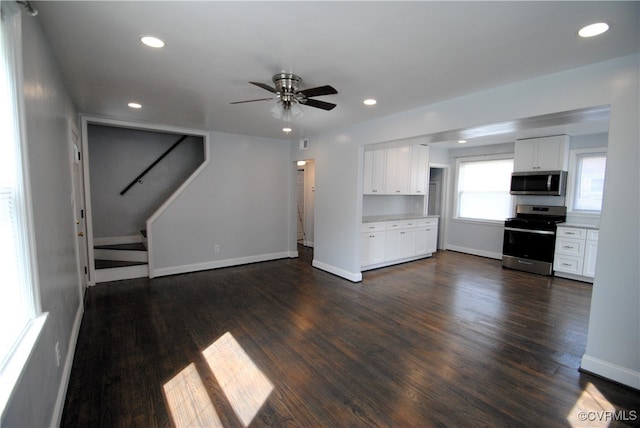 unfurnished living room with ceiling fan and dark wood-type flooring