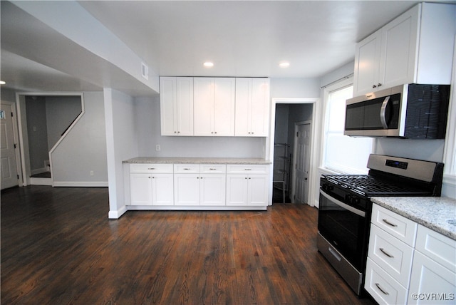 kitchen featuring stainless steel appliances, dark wood-type flooring, and white cabinetry