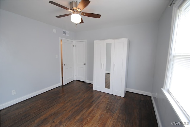 unfurnished bedroom featuring a closet, ceiling fan, and dark hardwood / wood-style flooring