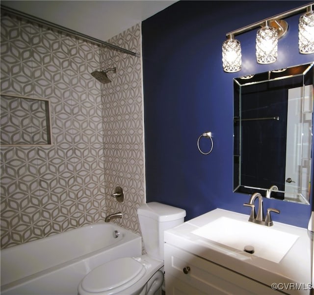 full bathroom with tiled shower / bath, vanity, and toilet