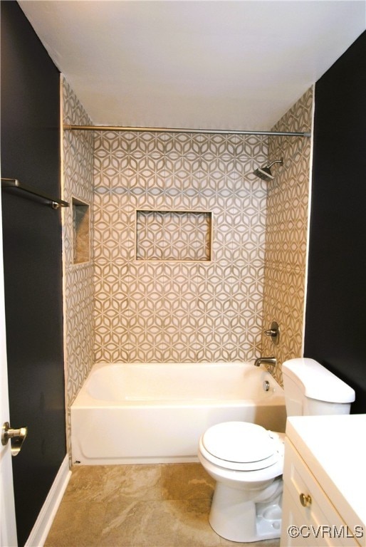 full bathroom featuring vanity, tiled shower / bath combo, and toilet