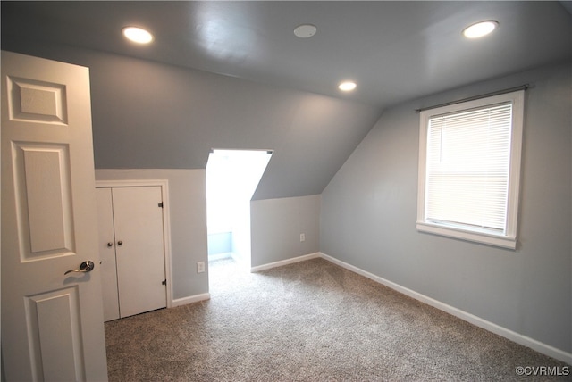 additional living space featuring lofted ceiling and carpet floors