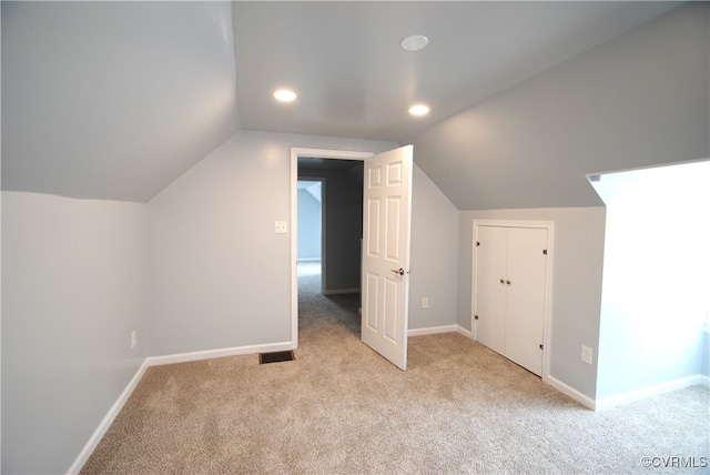 bonus room featuring vaulted ceiling and light carpet