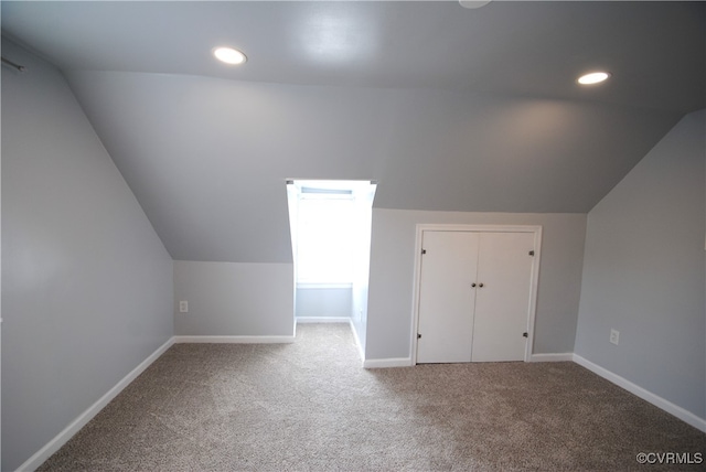 additional living space featuring lofted ceiling and carpet flooring