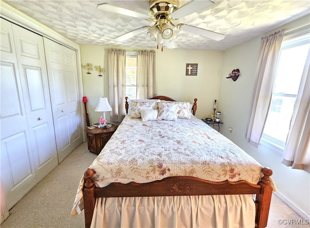 bedroom with multiple windows, ceiling fan, and a closet