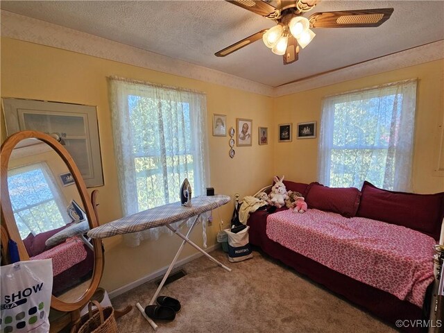 carpeted bedroom with a textured ceiling and ceiling fan