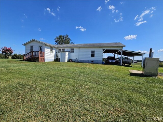 back of property with a lawn and a carport