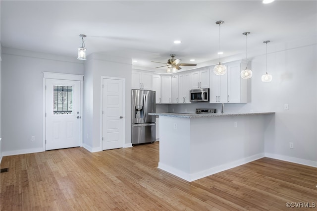 kitchen featuring white cabinetry, kitchen peninsula, pendant lighting, light hardwood / wood-style floors, and appliances with stainless steel finishes