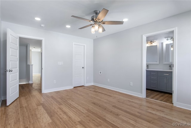 unfurnished bedroom featuring ensuite bath, ceiling fan, and light wood-type flooring