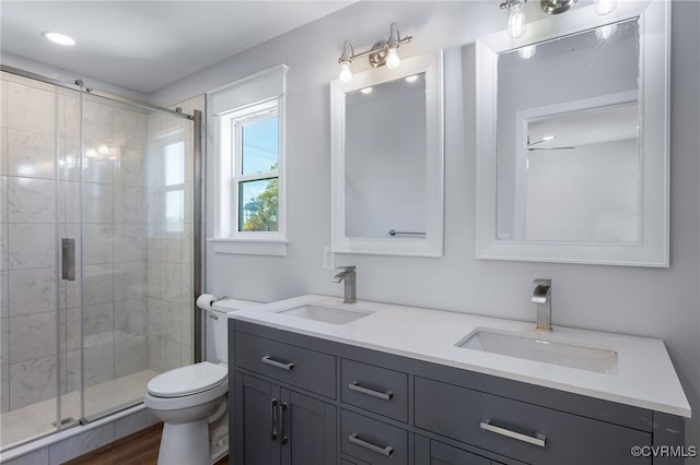 bathroom featuring vanity, toilet, hardwood / wood-style flooring, and a shower with door