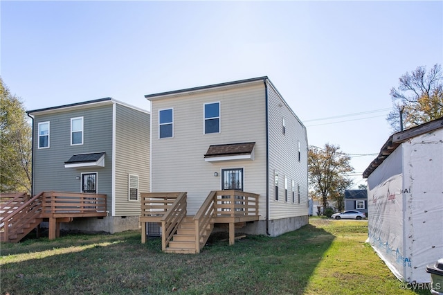 rear view of house featuring a lawn and a wooden deck