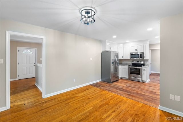 kitchen featuring white cabinetry, light hardwood / wood-style floors, and appliances with stainless steel finishes