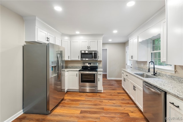 kitchen with light hardwood / wood-style flooring, white cabinets, appliances with stainless steel finishes, and sink