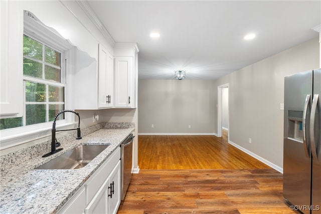 kitchen with wood-type flooring, white cabinetry, appliances with stainless steel finishes, and sink