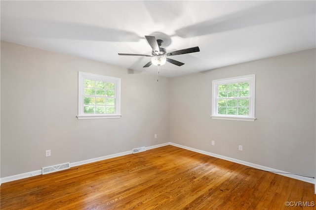 empty room with ceiling fan and hardwood / wood-style floors