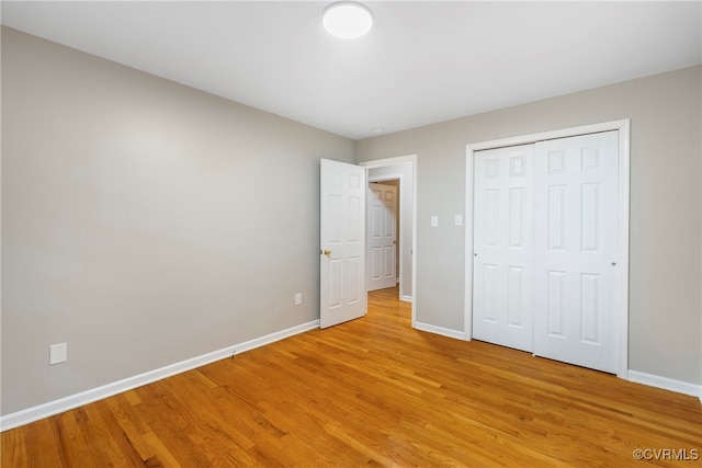 unfurnished bedroom featuring light hardwood / wood-style floors and a closet