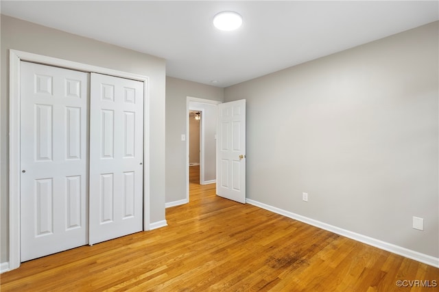 unfurnished bedroom featuring light wood-type flooring and a closet