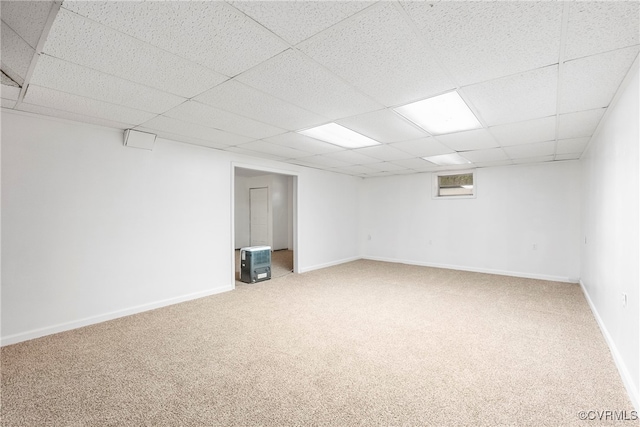 basement with a paneled ceiling and carpet flooring