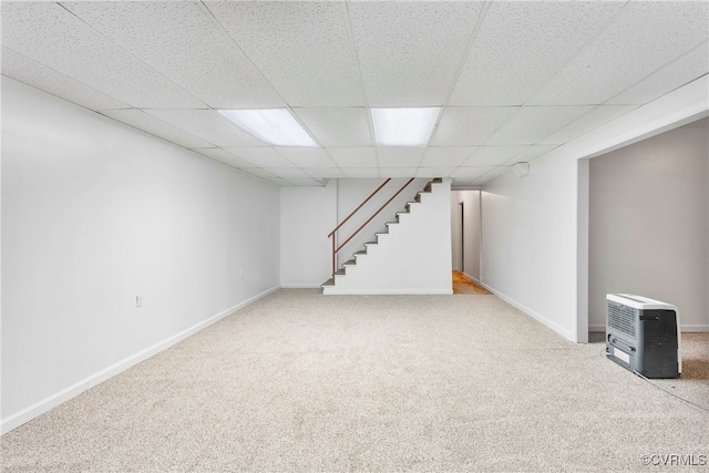 basement featuring carpet floors and a paneled ceiling