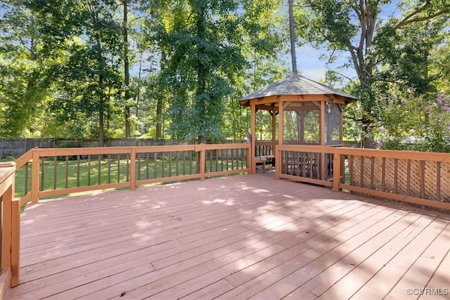 wooden terrace featuring a lawn and a gazebo