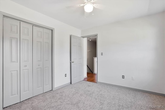 unfurnished bedroom with ceiling fan, a closet, and carpet