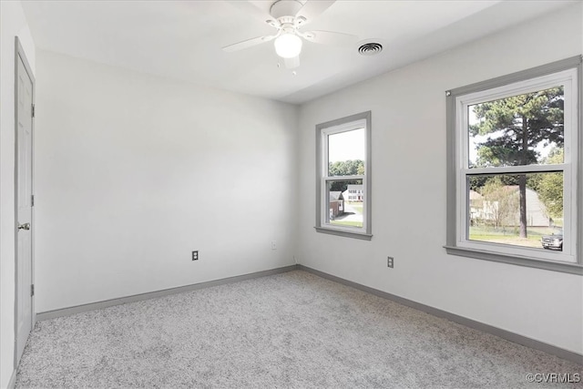 carpeted spare room with ceiling fan and a healthy amount of sunlight