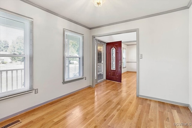 foyer featuring light wood-type flooring and crown molding