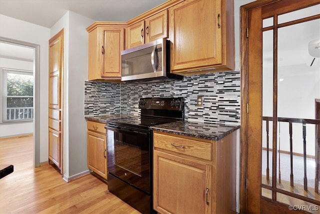 kitchen featuring light hardwood / wood-style flooring, dark stone countertops, decorative backsplash, and electric range