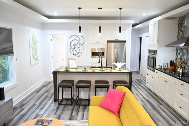 kitchen featuring white cabinets, pendant lighting, sink, appliances with stainless steel finishes, and a kitchen bar