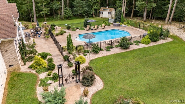 view of swimming pool with a storage unit, a patio, and a yard