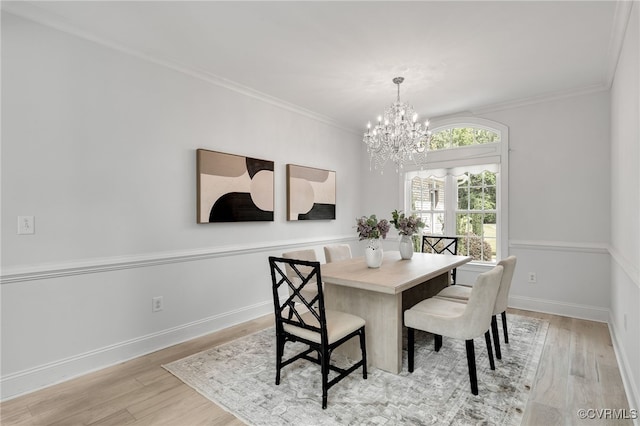 dining room featuring an inviting chandelier, light wood-type flooring, and ornamental molding