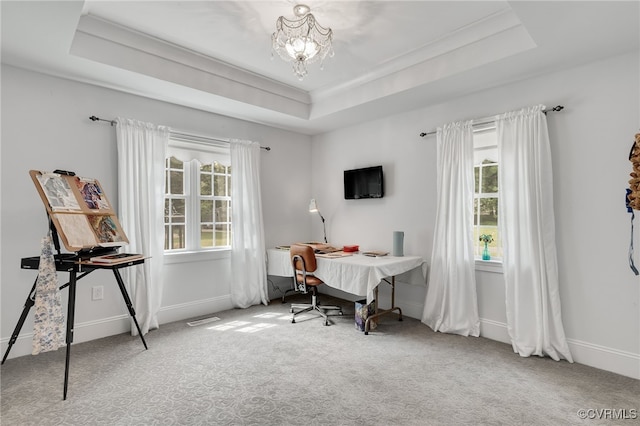 carpeted home office featuring a raised ceiling, plenty of natural light, and a chandelier