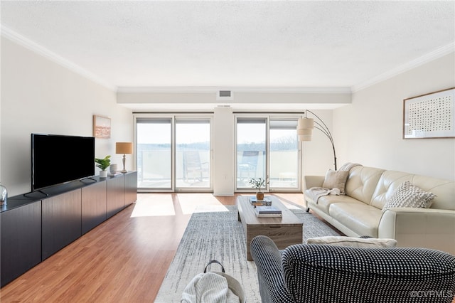 living room featuring crown molding, a textured ceiling, and light hardwood / wood-style flooring