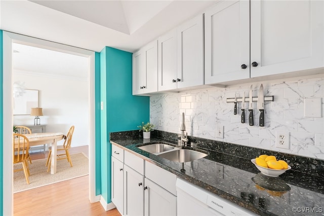 kitchen featuring sink, white cabinets, backsplash, and dark stone counters