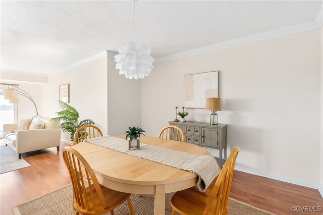 dining room featuring an inviting chandelier, hardwood / wood-style flooring, and ornamental molding