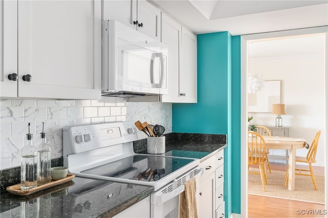 kitchen with white appliances, light hardwood / wood-style floors, decorative backsplash, and white cabinets