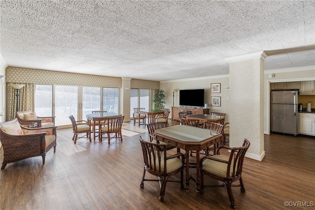 dining area featuring hardwood / wood-style floors, ornamental molding, and a textured ceiling