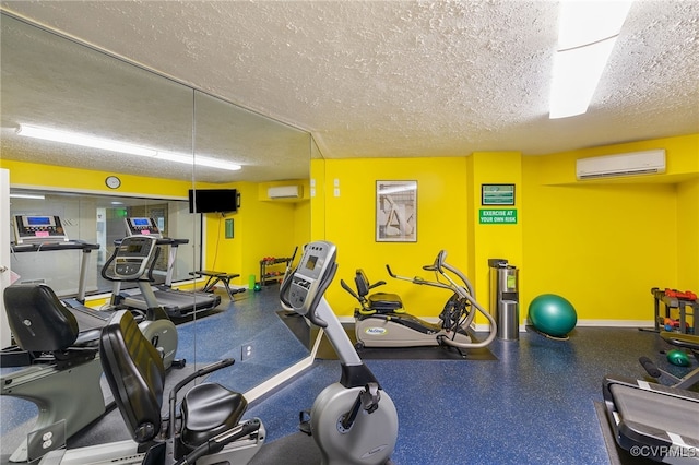 workout area featuring a wall mounted air conditioner and a textured ceiling