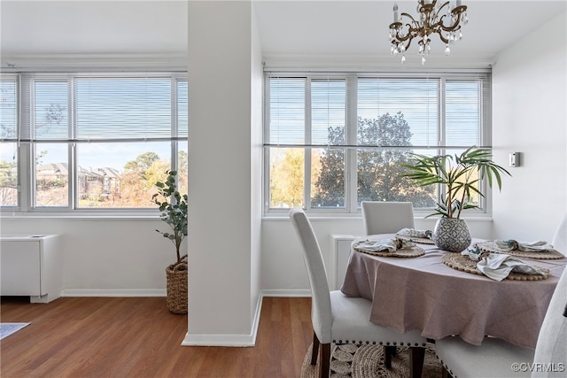 dining space featuring hardwood / wood-style flooring and an inviting chandelier