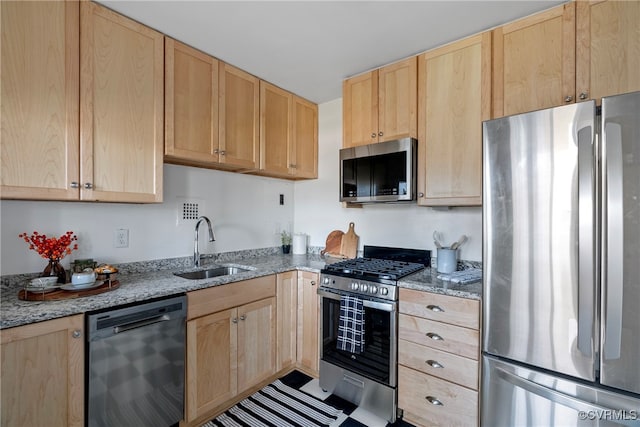 kitchen featuring light stone counters, sink, stainless steel appliances, and light brown cabinets