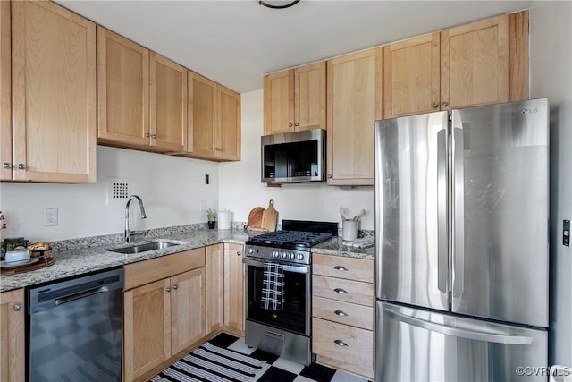 kitchen featuring light stone counters, sink, light brown cabinets, and appliances with stainless steel finishes