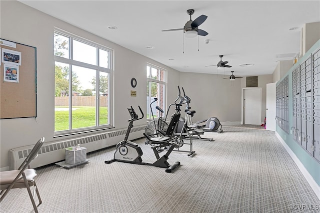 workout room with carpet flooring, ceiling fan, and a baseboard heating unit