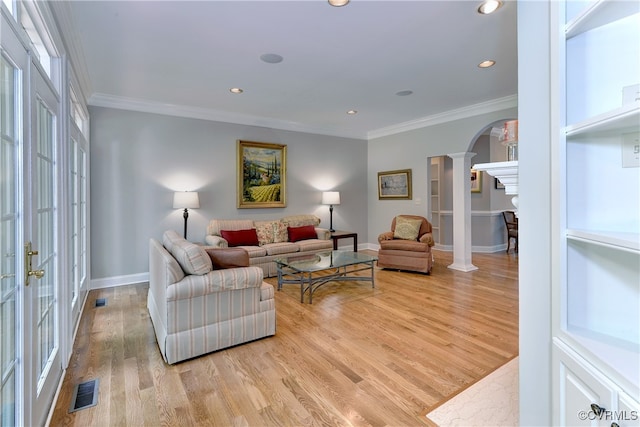 living room with french doors, ornamental molding, light hardwood / wood-style floors, and decorative columns