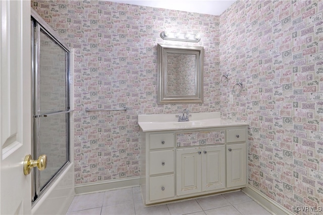 bathroom with bath / shower combo with glass door, vanity, and tile patterned flooring