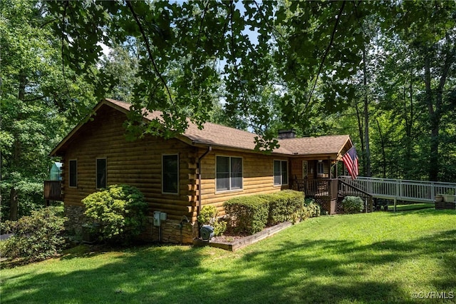 view of side of property featuring a lawn and a deck