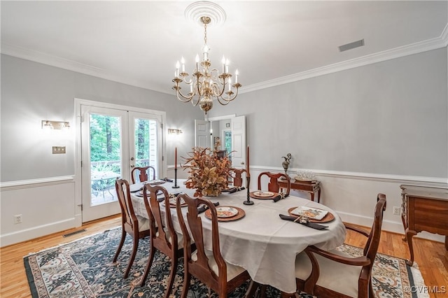 dining space with ornamental molding, light hardwood / wood-style floors, and french doors