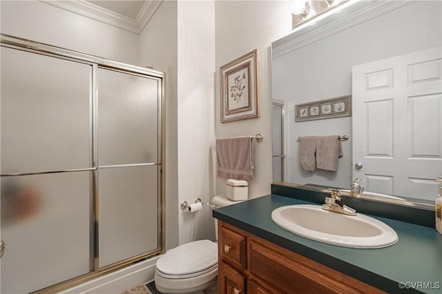 bathroom with ornamental molding, toilet, a shower with door, and vanity