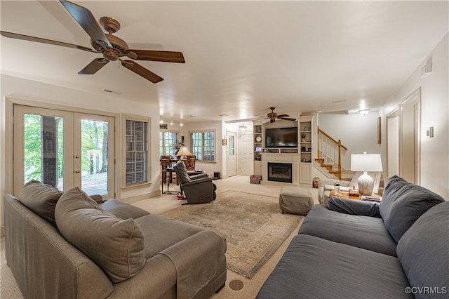 living room with french doors, ceiling fan, and light carpet